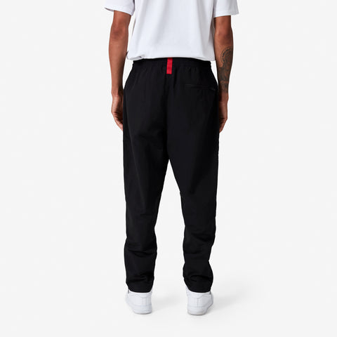back of 100 Thieves Foundation nylon pants with elastic waistband and 100 Thieves metal aglet tipped drawstrings in the color black