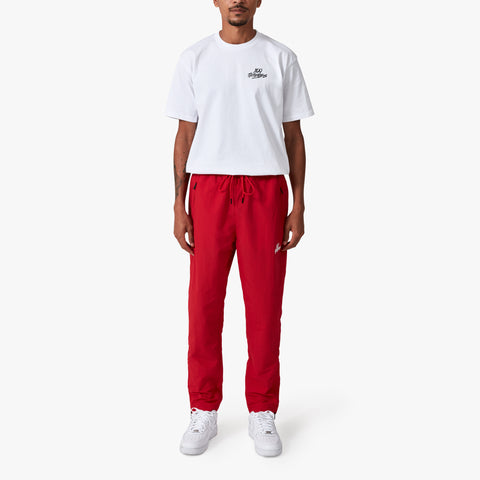 100 Thieves Foundation nylon pants with elastic waistband and 100 Thieves metal aglet tipped drawstrings in the color red