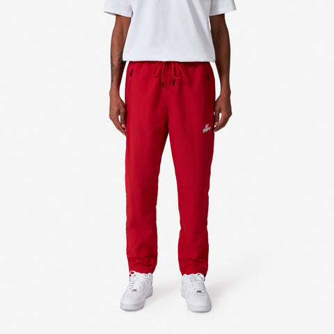 100 Thieves Foundation nylon pants with elastic waistband and 100 Thieves metal aglet tipped drawstrings in the color red