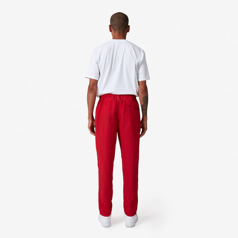back of 100 Thieves Foundation nylon pants with elastic waistband and 100 Thieves metal aglet tipped drawstrings in the color red